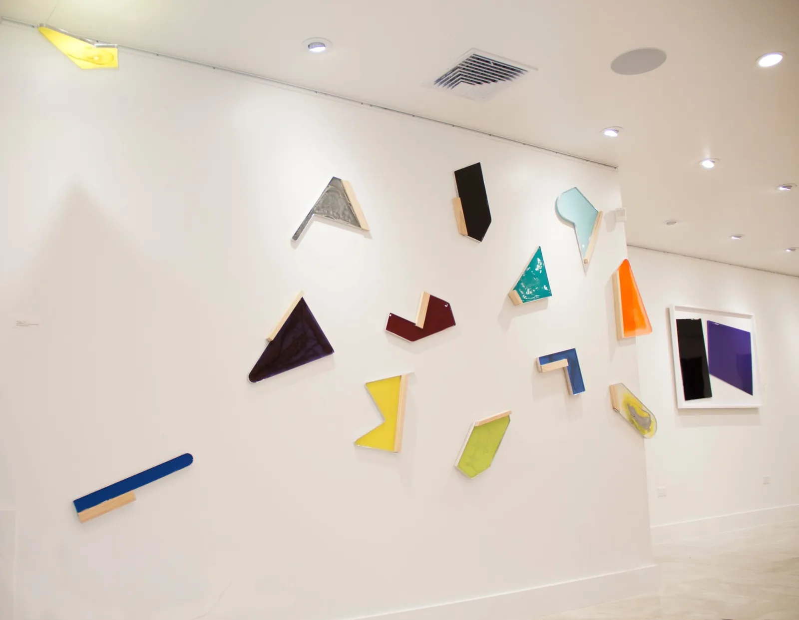 Thoughts, 2017: pigmented resin, wood and metal shapes installed across a white wall at Kendall Art Center